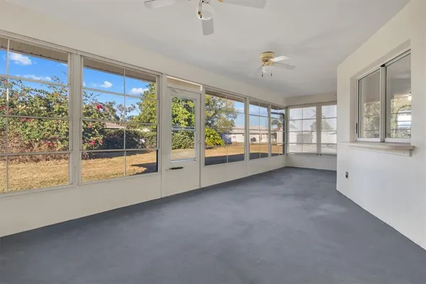 a view of a big room with windows and chandelier fan