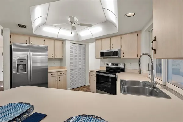 a kitchen with stainless steel appliances granite countertop a sink a stove and a refrigerator