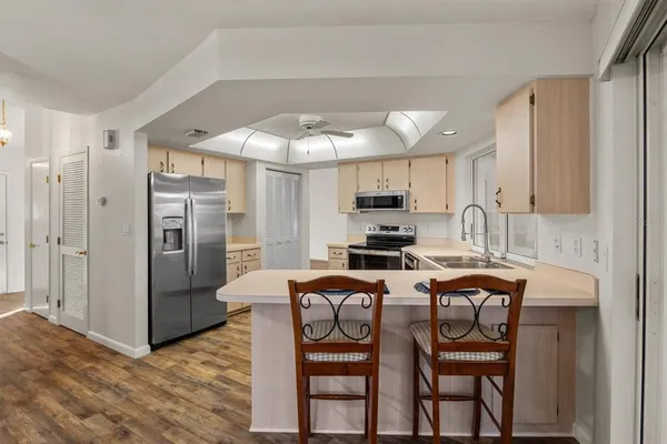 a kitchen with stainless steel appliances a table chairs refrigerator and microwave