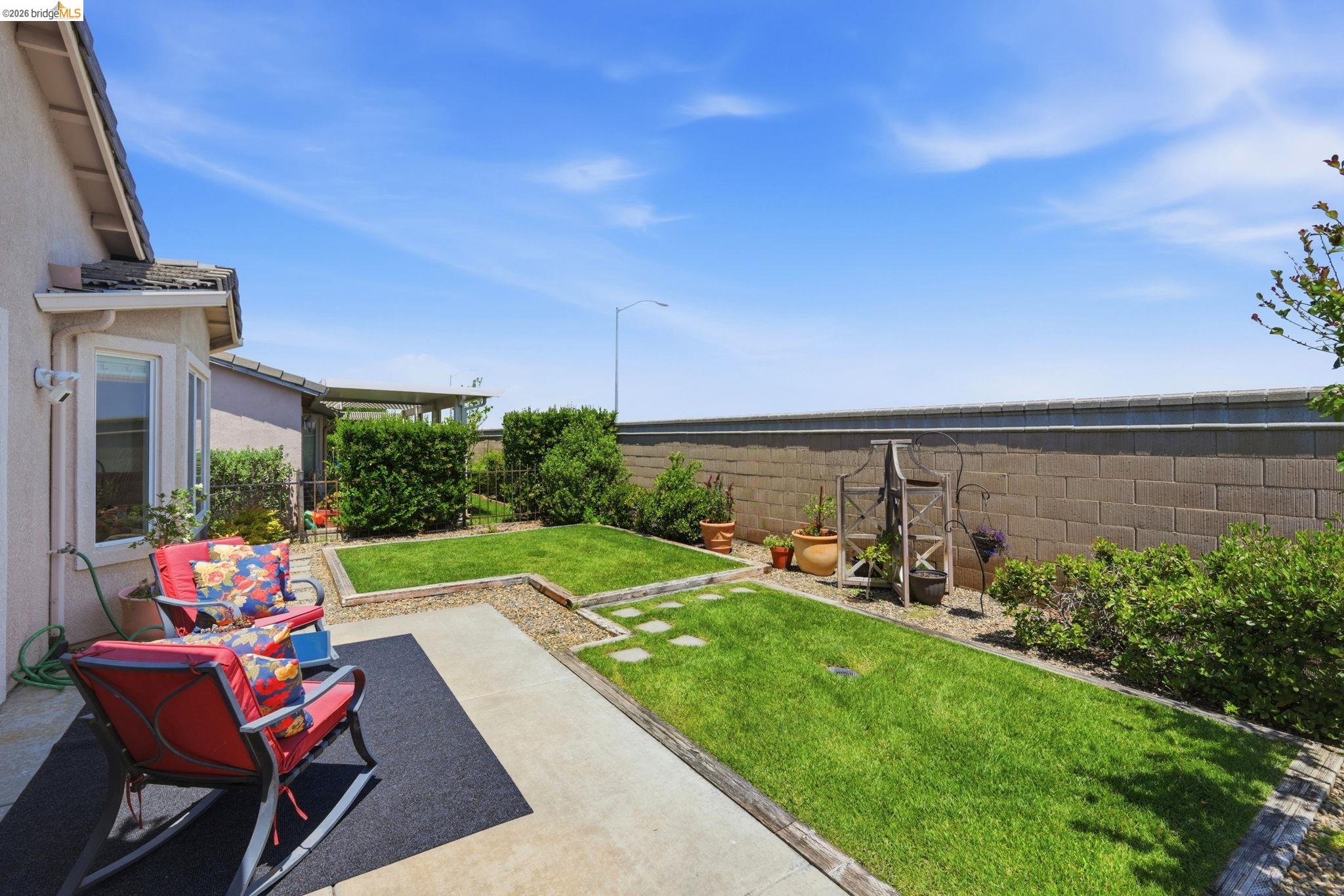 1024 Diamante Rio Vista, CA 94571 - Photo 22 of 27 Expansive backyard featuring a concrete patio, manicured lawn areas, mature perimeter shrubs, and a block wall border