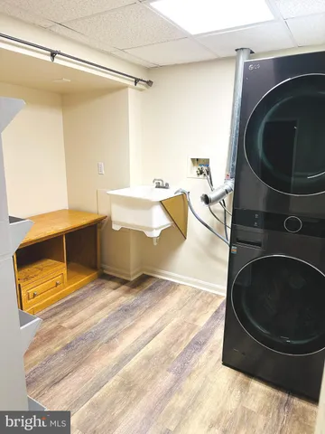 a living room with stainless steel appliances furniture and a washer dryer