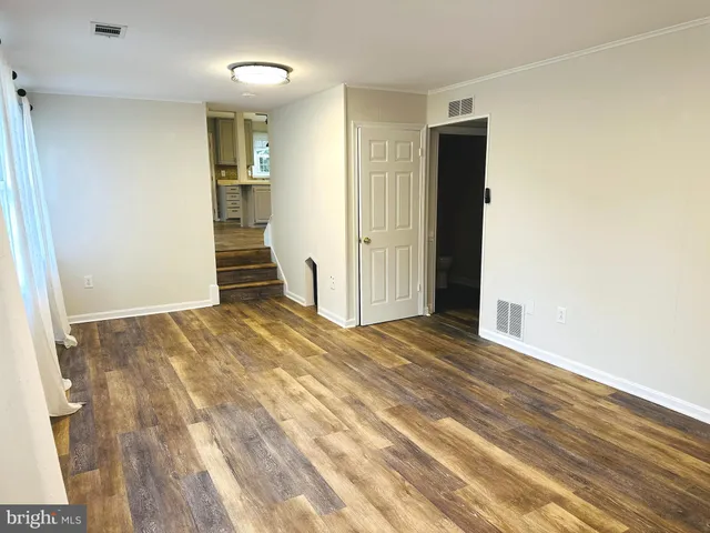an empty room with wooden floor and entrance