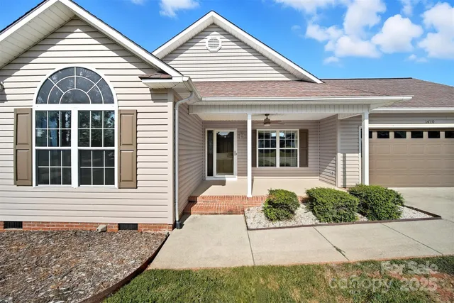 a front view of a house with a yard and potted plants