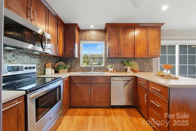 a kitchen with stainless steel appliances granite countertop a stove a sink and a microwave
