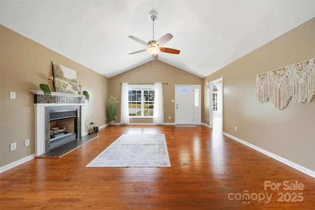 a view of livingroom with fireplace window and wooden floor