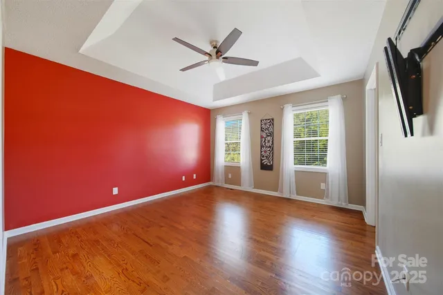 a view of a livingroom with a ceiling fan and wooden floor