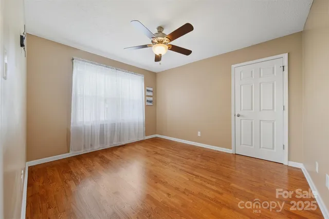 an empty room with closet and ceiling fan