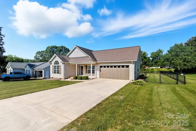 a view of a house with a big yard plants and large trees