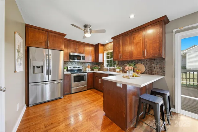 a kitchen with kitchen island a counter top space stainless steel appliances and cabinets