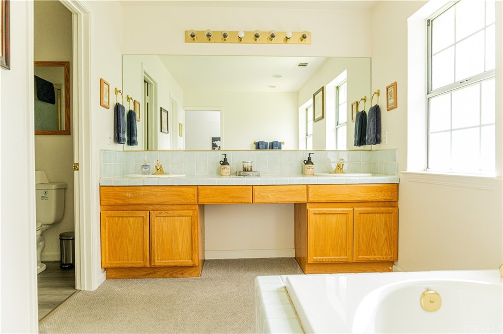 39301 Moonray Lane Oakhurst, CA 93644 - Photo 15 of 41 a bathroom with a tub sink and mirror