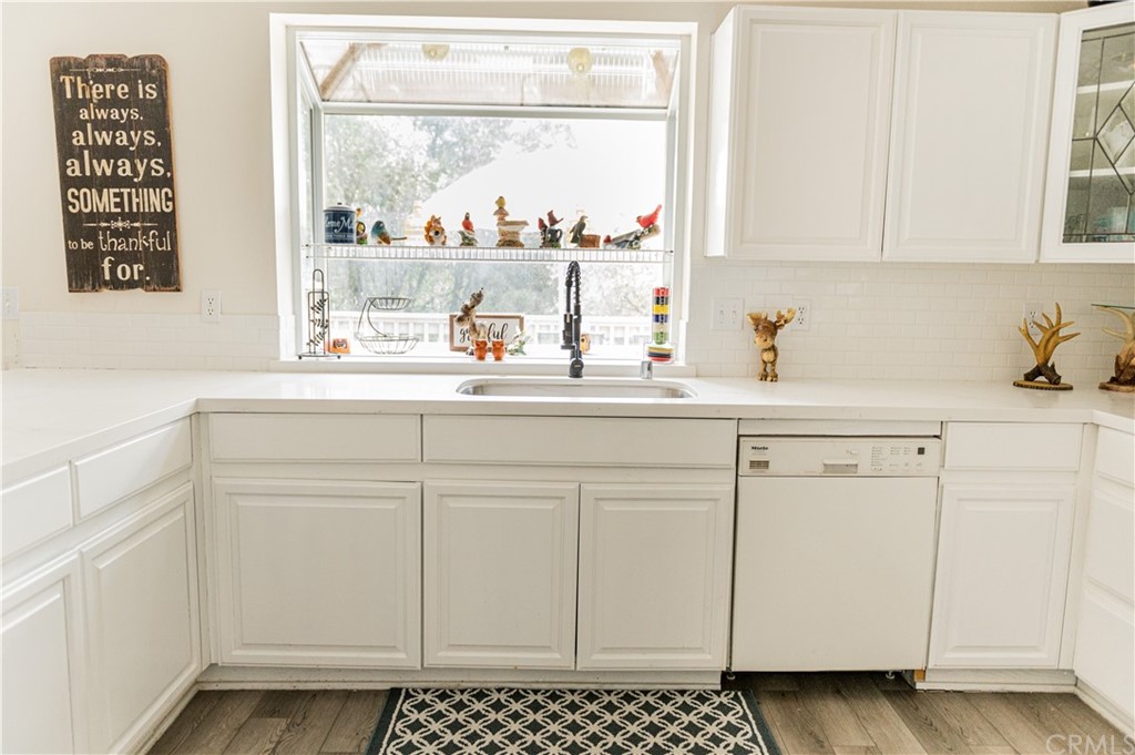 39301 Moonray Lane Oakhurst, CA 93644 - Photo 21 of 41 a kitchen with white cabinets and window