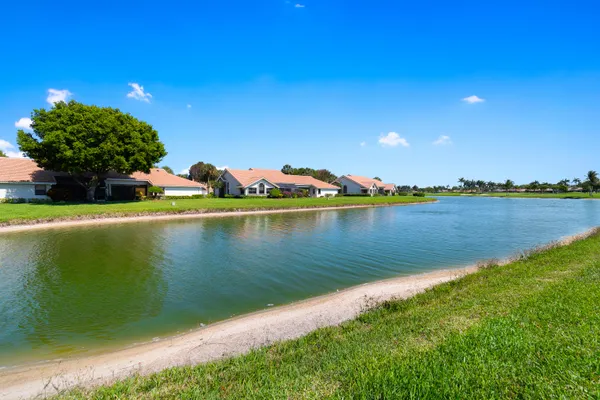 a front view of a house with a garden and trees