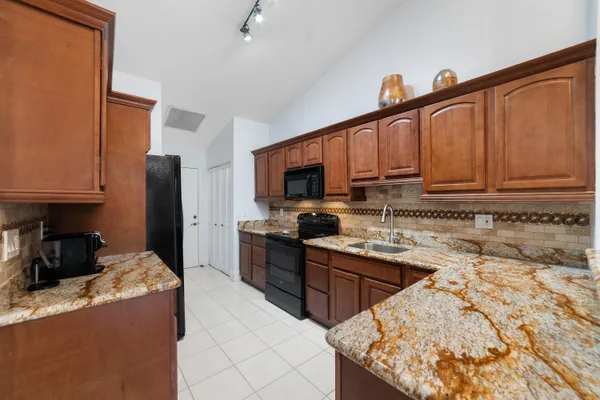 a kitchen with granite countertop a sink stove and cabinets