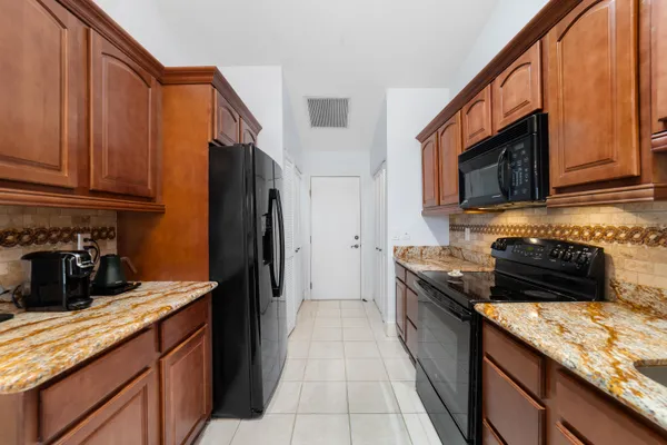 a kitchen with stainless steel appliances kitchen island a table and chairs in it