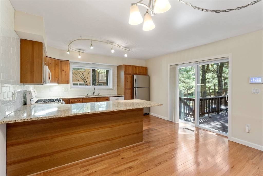 106 Captain Eames Circle, Unit 106 Ashland, MA 01721 - Photo 4 of 21 a large kitchen with granite countertop a large window and white cabinets