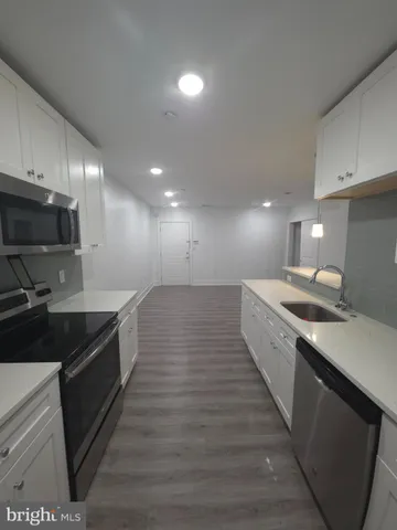 a large kitchen with granite countertop a sink and a stove top oven