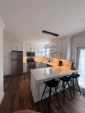 a kitchen with a table chairs refrigerator and cabinets
