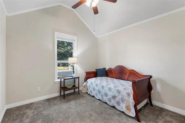 a bedroom with a bed and a chandelier fan