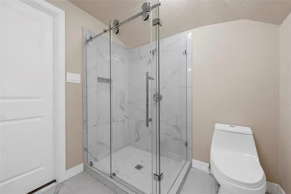 a bathroom with a shower a toilet and sink