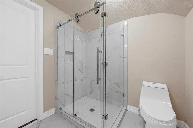 a bathroom with a shower a toilet and sink