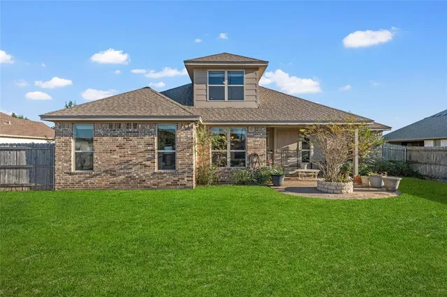 a front view of a house with patio and garden