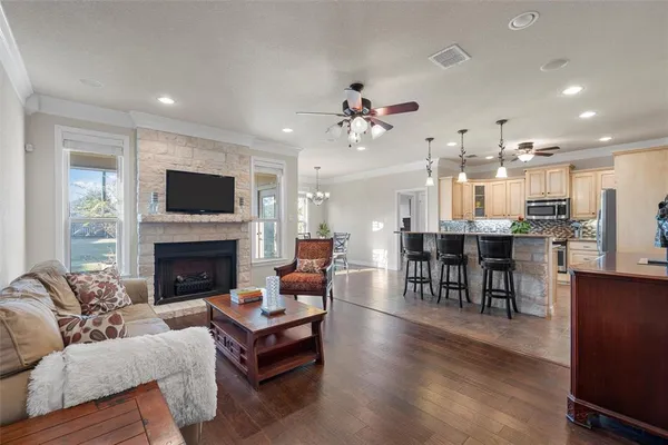 a living room with furniture kitchen view and a chandelier