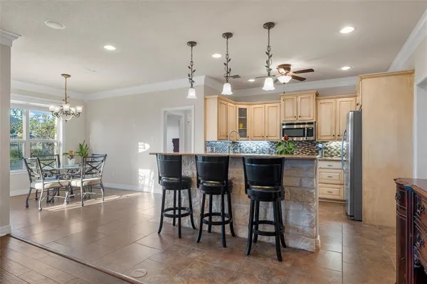 a kitchen with kitchen island granite countertop a table and chairs in it