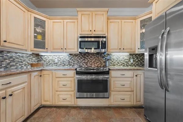 a kitchen with stainless steel appliances granite countertop a stove a refrigerator and a sink