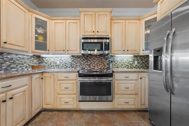 a kitchen with stainless steel appliances granite countertop a stove a refrigerator and a sink