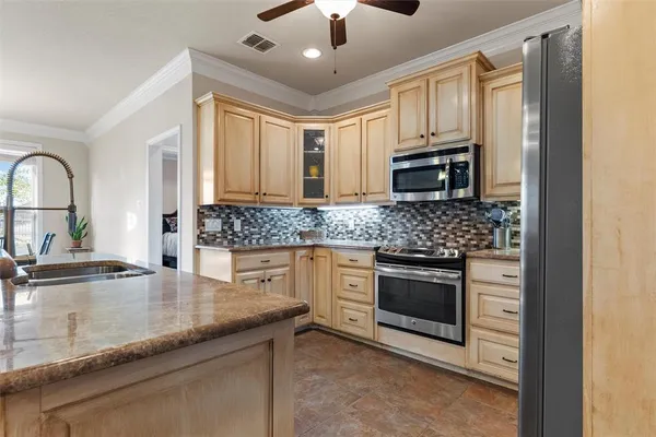 a kitchen with granite countertop a sink stainless steel appliances and cabinets