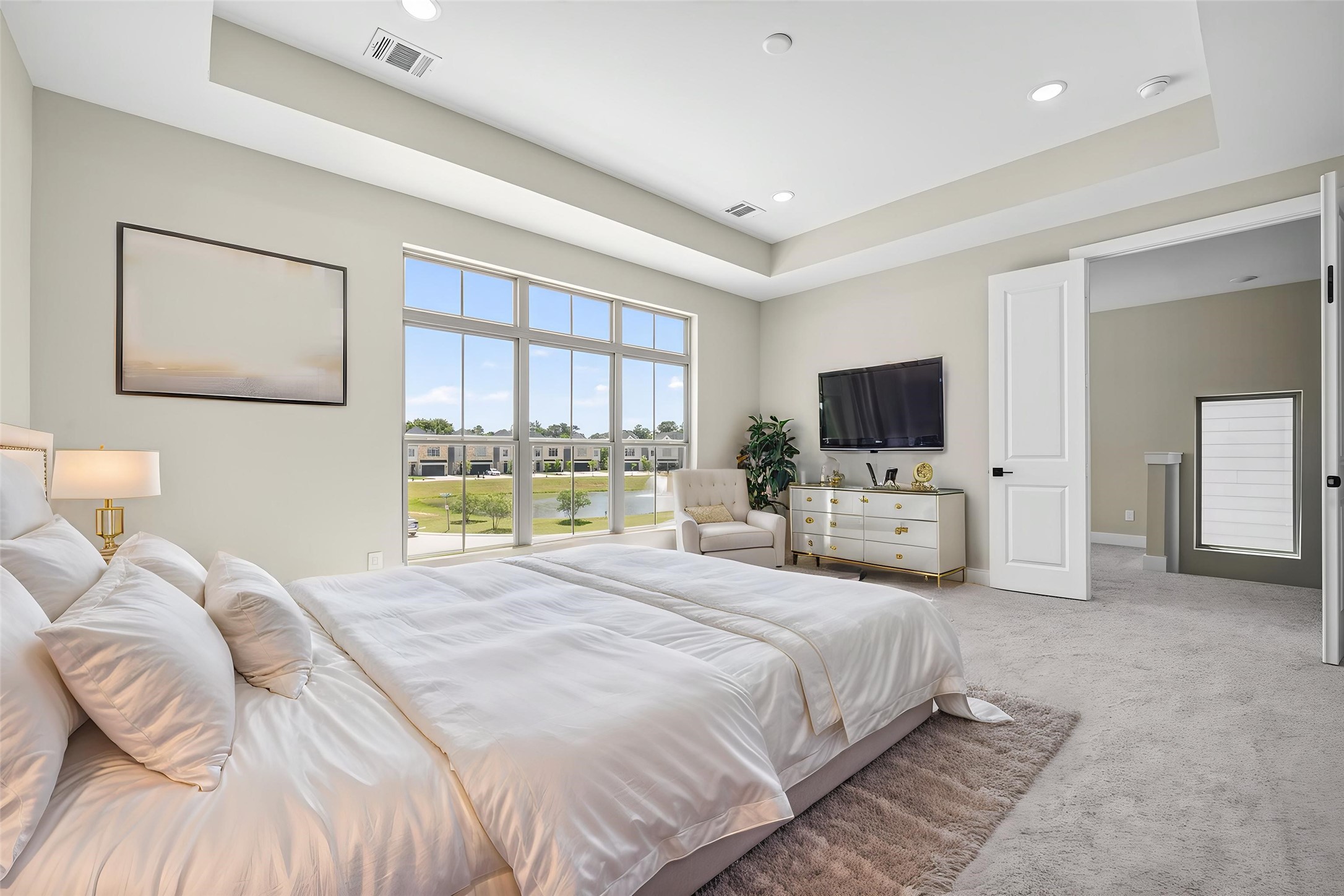 4930 Wunder Way Houston, TX 77069 - Photo 5 of 23 This AI-staged oversized bedroom boasts a serene, sunlit ambiance with elegant decor, inviting you to envision your perfect retreat with a water view.