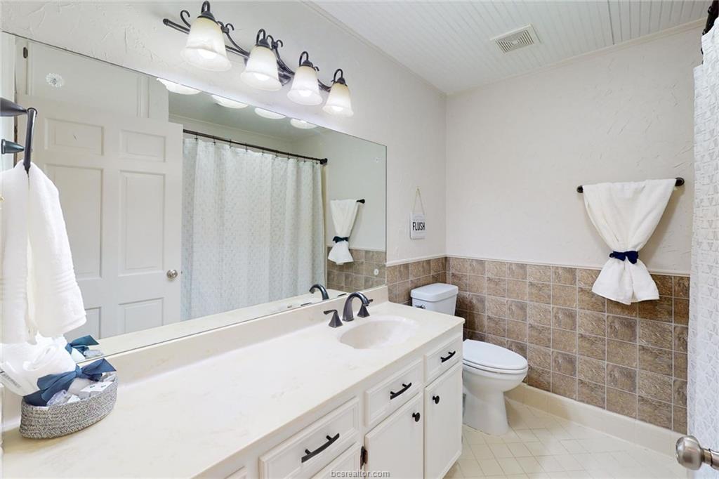 900 Westview Street Bryan, TX 77802 - Photo 18 of 30 a bathroom with a sink a toilet and mirror