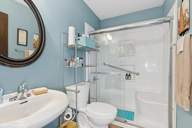 a bathroom with a sink mirror toilet and shower
