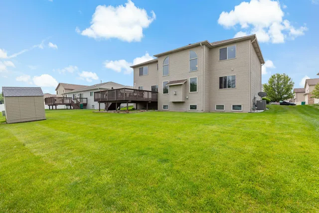 a view of a house with a big yard and large trees