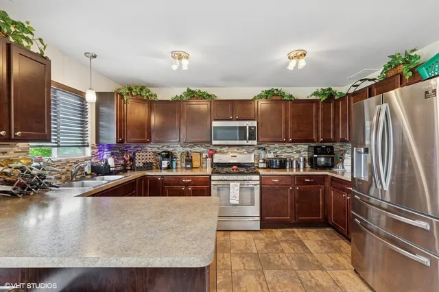 a kitchen with kitchen island granite countertop a stove refrigerator and a sink