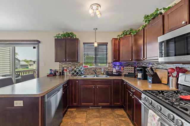 a kitchen with stainless steel appliances a sink stove and cabinets
