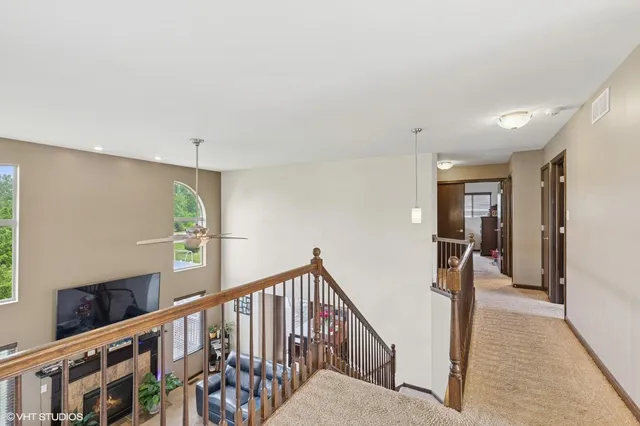 a view of staircase with lots of frames on wall and a window