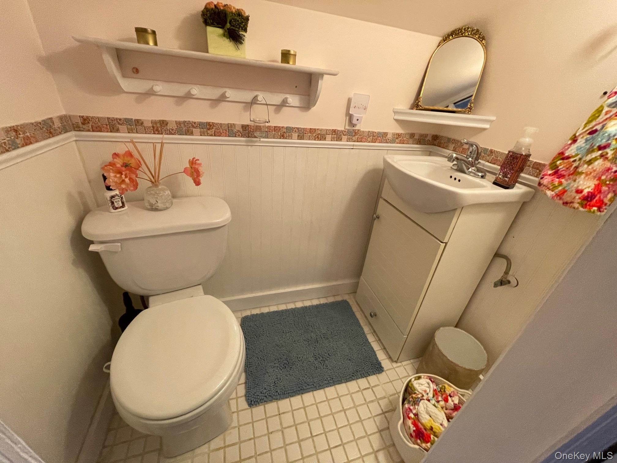 70 Shell Road Rocky Point, NY 11778 - Photo 18 of 31 Half bath featuring wainscoting, vanity, and light tile patterned floors