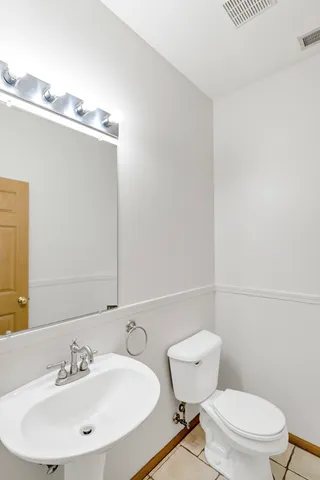 a bathroom with a toilet a sink and mirror