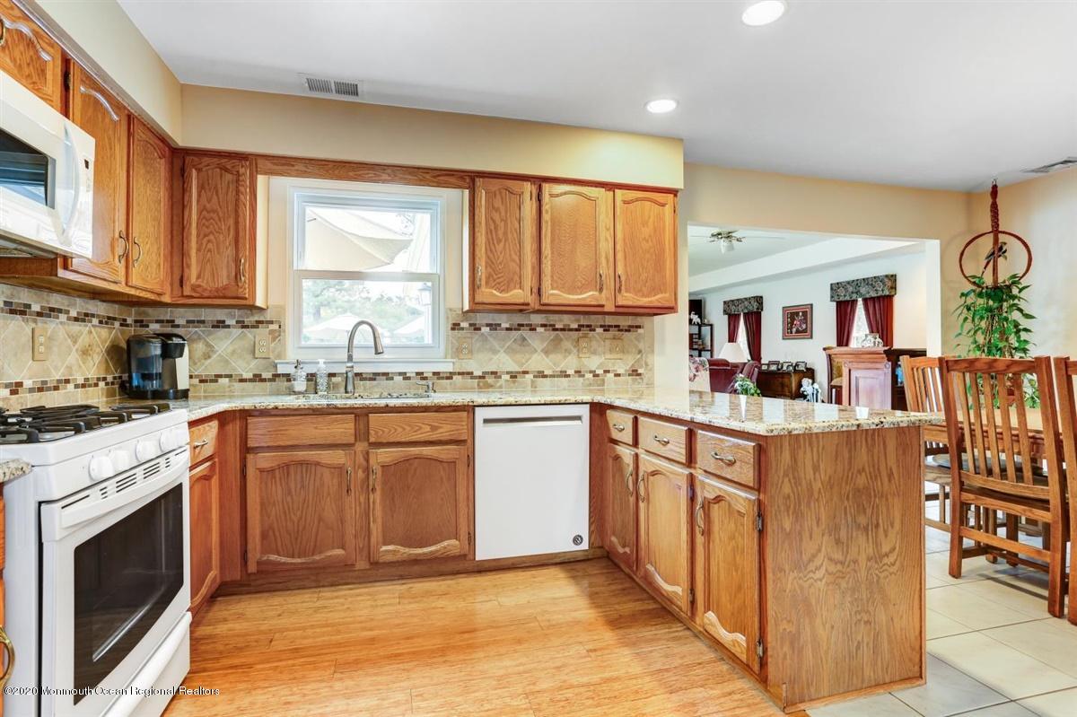 40 Hedgewood Road Howell, NJ 07731 - Photo 11 of 39 a kitchen with stainless steel appliances granite countertop a stove top oven a sink dishwasher and a microwave oven with large cabinets