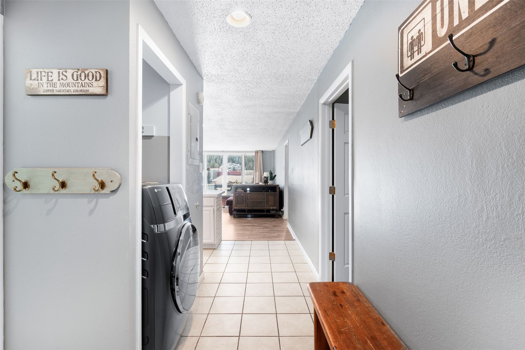 760 Copper Road, Unit F204 Copper Mountain, CO 80443 - Photo 21 of 32 Corridor with a textured ceiling, light tile patterned flooring, and separate washer and dryer