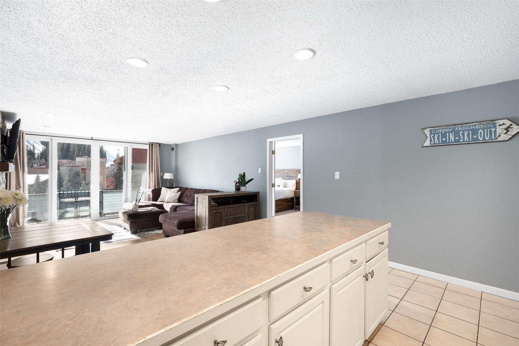 760 Copper Road, Unit F204 Copper Mountain, CO 80443 - Photo 8 of 32 Kitchen featuring white cabinetry, a textured ceiling, light countertops, light tile patterned floors, and expansive windows