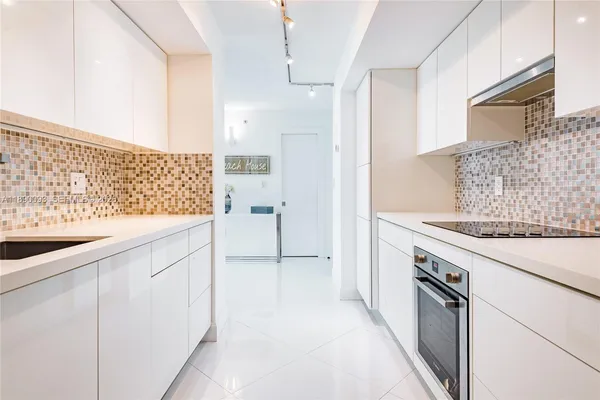 a kitchen with granite countertop white cabinets and white appliances