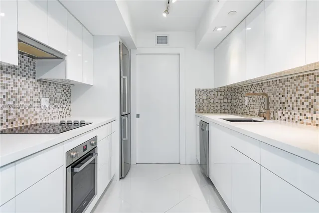 a kitchen with granite countertop white cabinets and white appliances