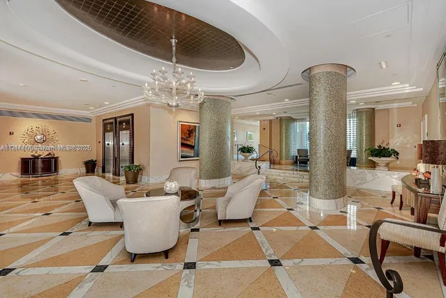 a living room with a table a chandelier and pool table