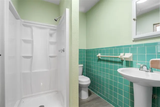 a bathroom with a sink a toilet and shower