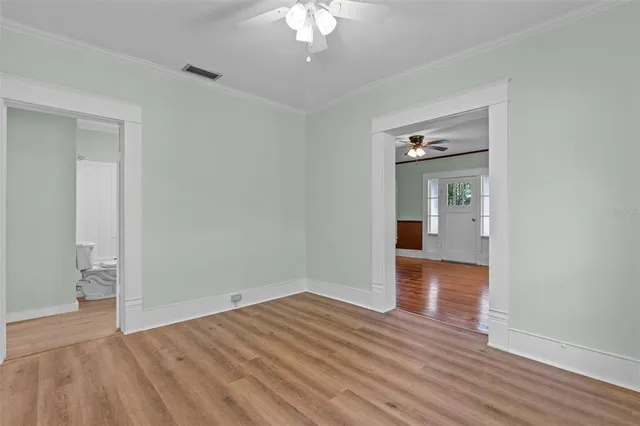 wooden floor in an empty room with a bathroom