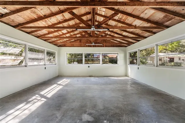 an aerial view of a house with a yard and covered with trees