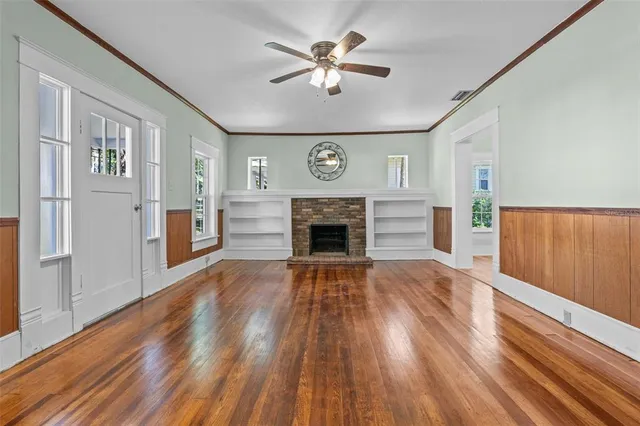 a view of empty room with a fireplace and wooden floor