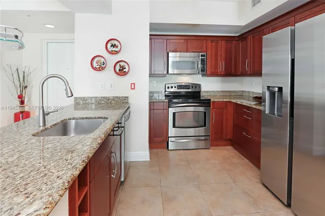a kitchen with stainless steel appliances granite countertop a sink stove and refrigerator